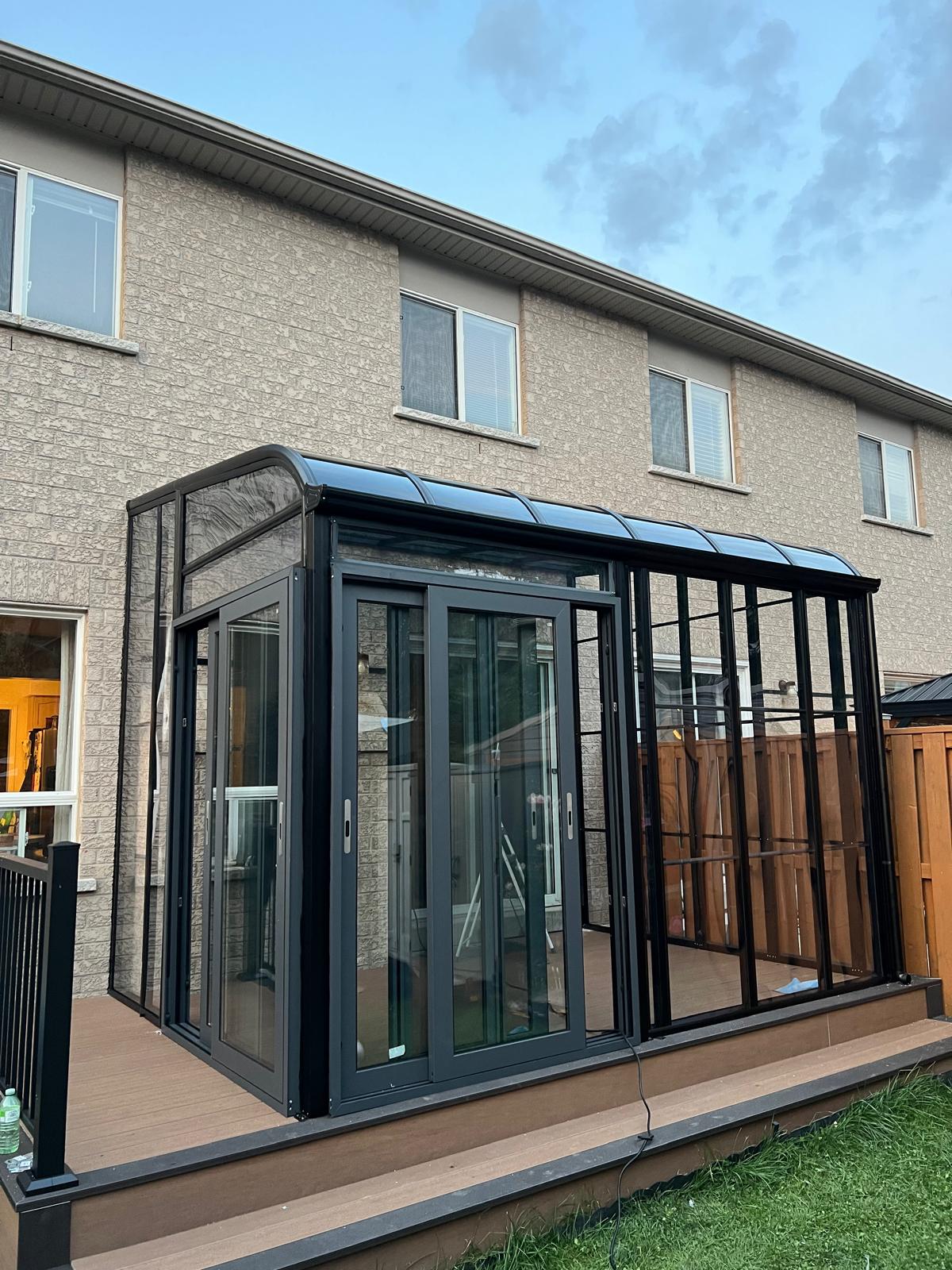 Glass sunroom addition with sliding doors, exterior view